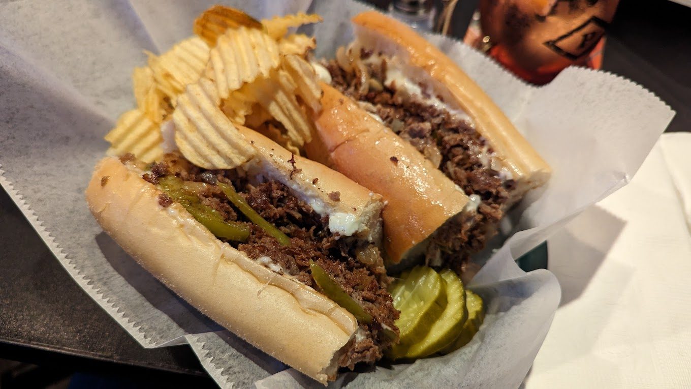 A Philly cheesesteak with melted cheese on a long roll