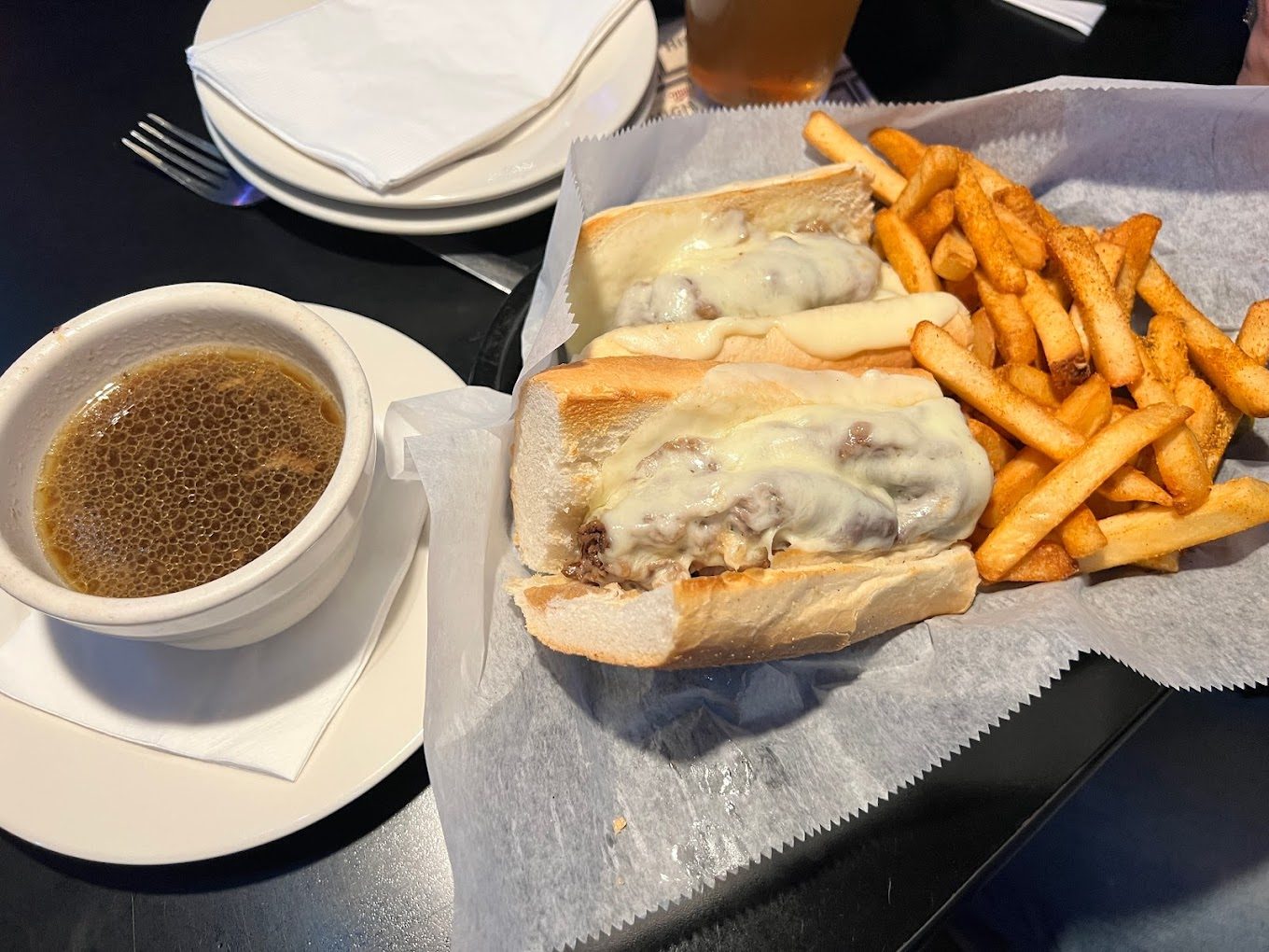 A French dip sandwich with au jus and fries