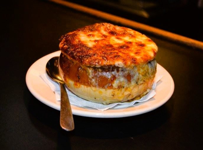 A crock of French onion soup with broiled cheese on top