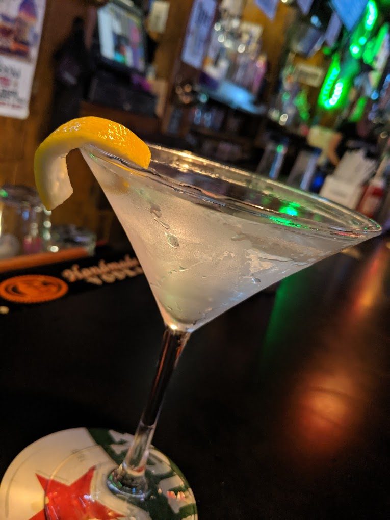 A martini with a lemon twist on the bar