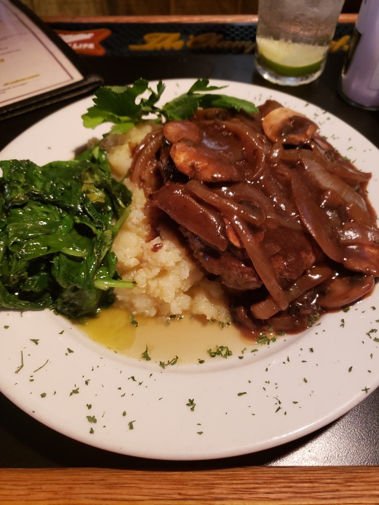 A roast platter with mashed potatoes and greens