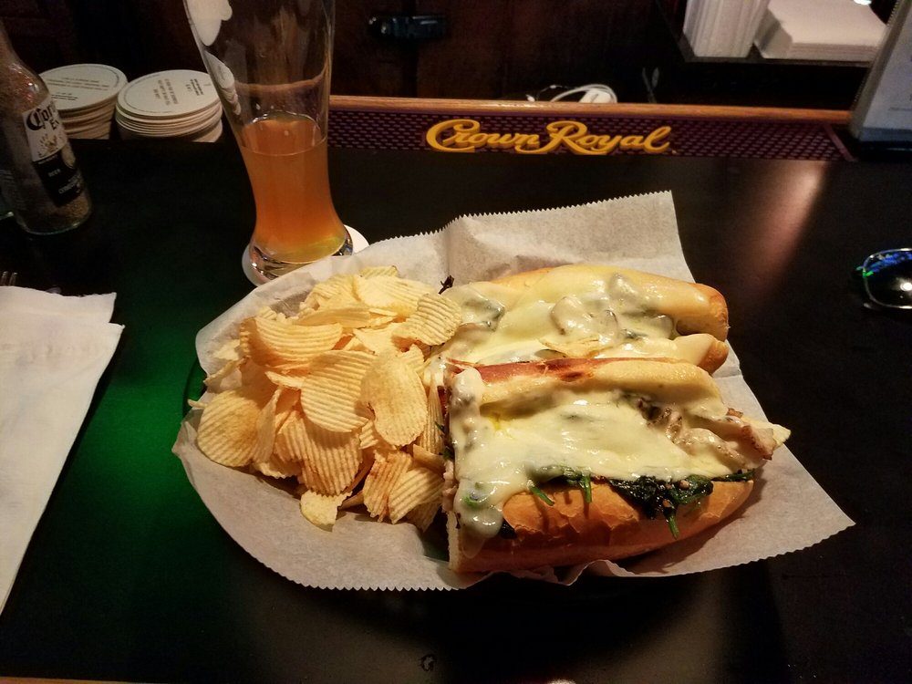A roast pork sandwich with chips at the bar