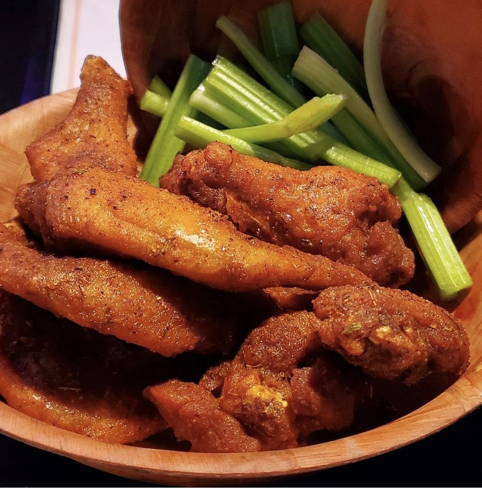 A basket of dry-rub chicken wings with celery sticks