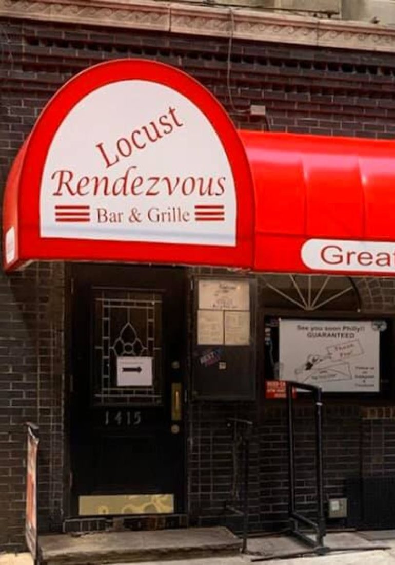 A restaurant with a red awning and a sign that says louis rendevous bar & grill.